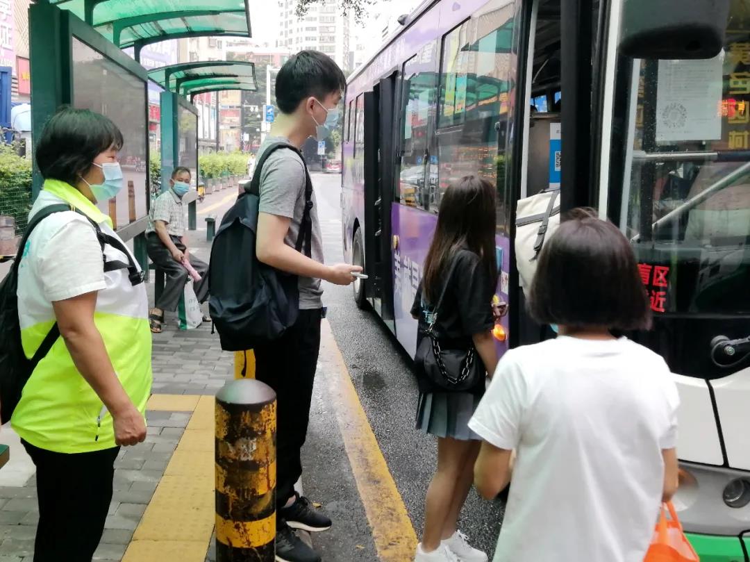 党员吴惠萍（左）提醒乘客提前“亮码”